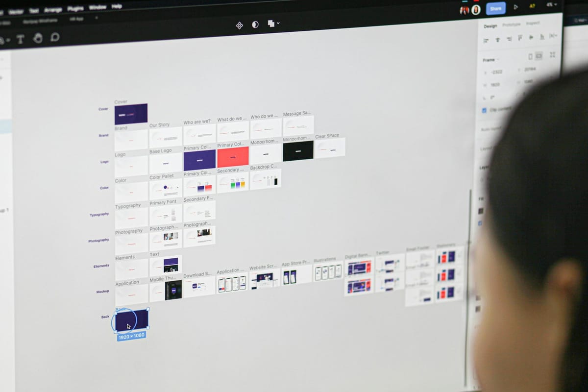 Designerin arbeitet am Monitor an einem Webprojekt: Seitenraster mit Layout-Entwürfen, Farbflächen und Typografie